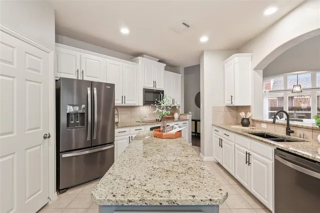 a kitchen with stainless steel appliances granite countertop a refrigerator stove and sink