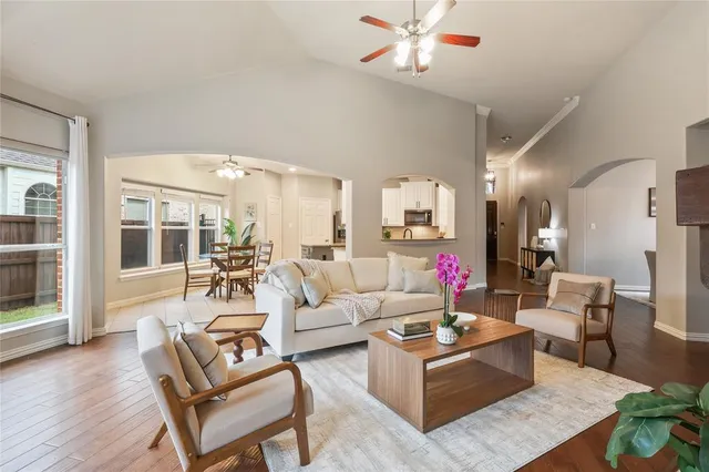 a living room with furniture kitchen view and a large window