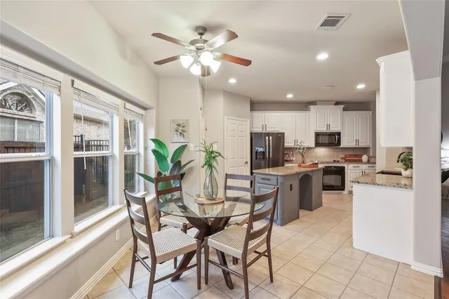 a view of kitchen with refrigerator stove dining table and chairs