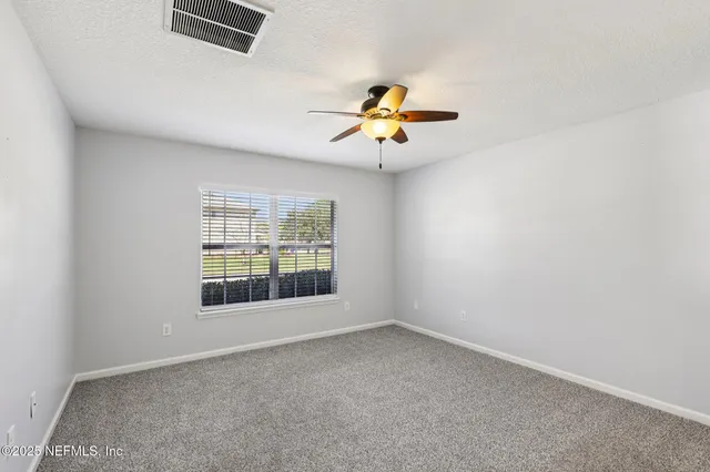 an empty room with closet and fan
