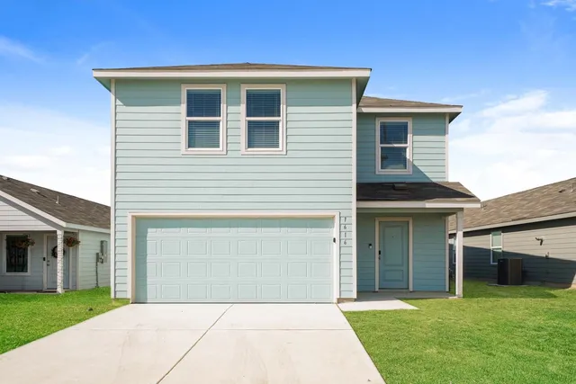 a front view of a house with a yard and garage