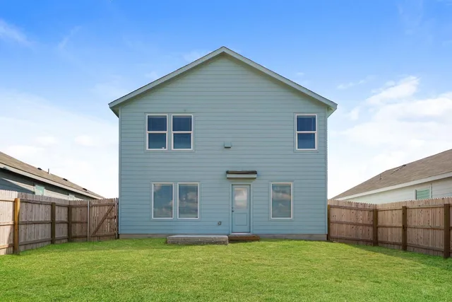 a view of a backyard with wooden fence