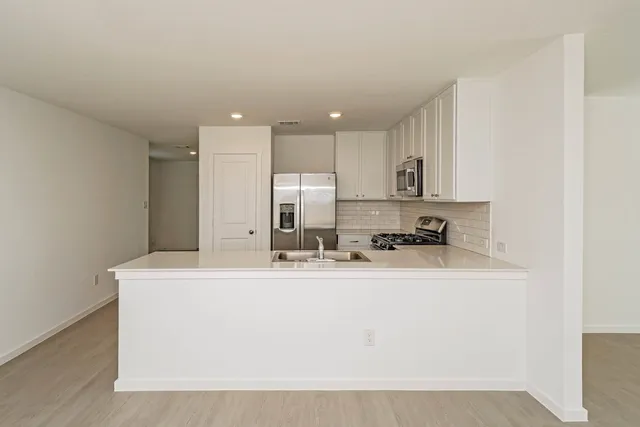 a kitchen with stainless steel appliances a refrigerator stove microwave and sink
