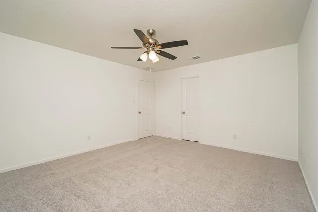 an empty room with a window and a ceiling fan