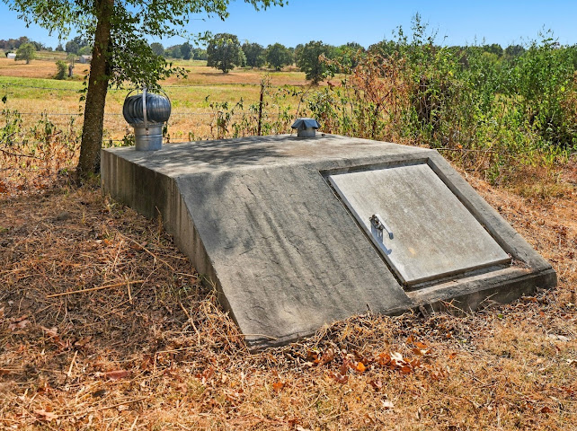 30063 South 4300th Road Stigler, OK 74462 - Photo 39 of 58 Concrete storm shelter with metal door, featuring a galvanized roof turbine vent and additional smaller vent