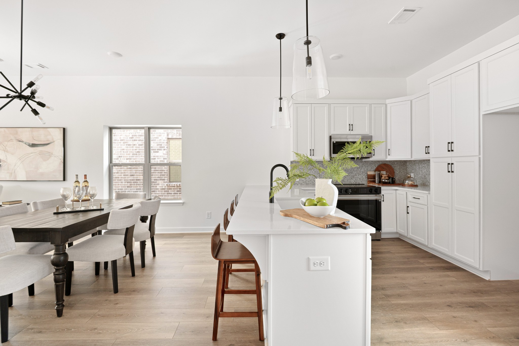 a kitchen with stainless steel appliances kitchen island granite countertop a stove a sink a dining table and chairs