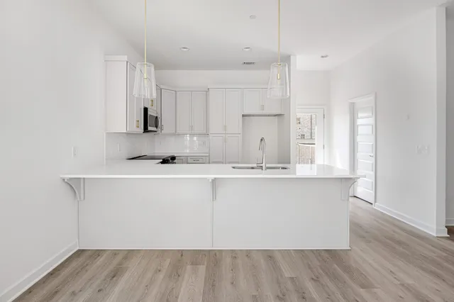 a kitchen with granite countertop white cabinets and stainless steel appliances