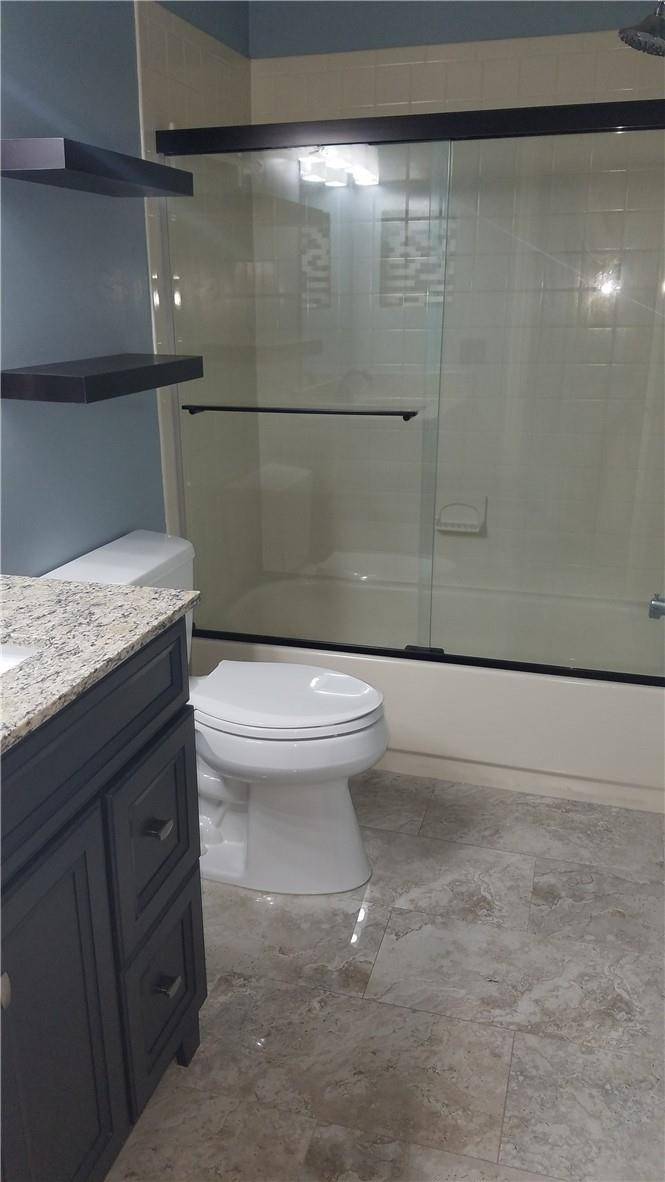 6659 Via Regina, Unit 6659 Boca Raton, FL 33433 - Photo 22 of 38 a bathroom with a granite countertop sink and a toilet