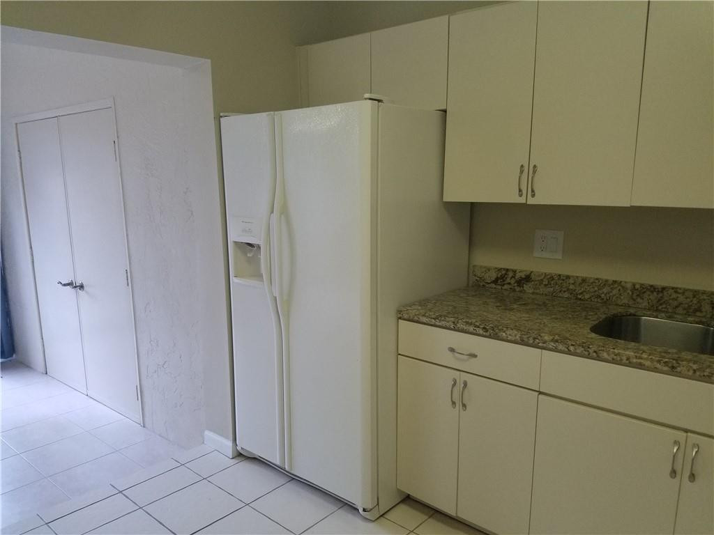 6659 Via Regina, Unit 6659 Boca Raton, FL 33433 - Photo 8 of 38 a kitchen with cabinets and white appliances