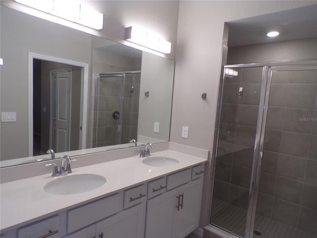 14271 Heritage Landing Boulevard, Unit 1526 Punta Gorda, FL 33955 - Photo 13 of 41 a bathroom with a double vanity sink mirror and shower