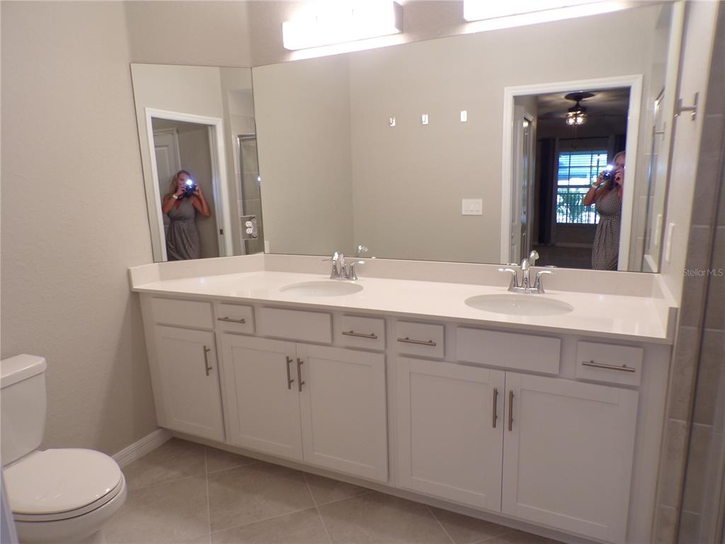 14271 Heritage Landing Boulevard, Unit 1526 Punta Gorda, FL 33955 - Photo 14 of 41 a bathroom with a toilet a sink a vanity and mirror