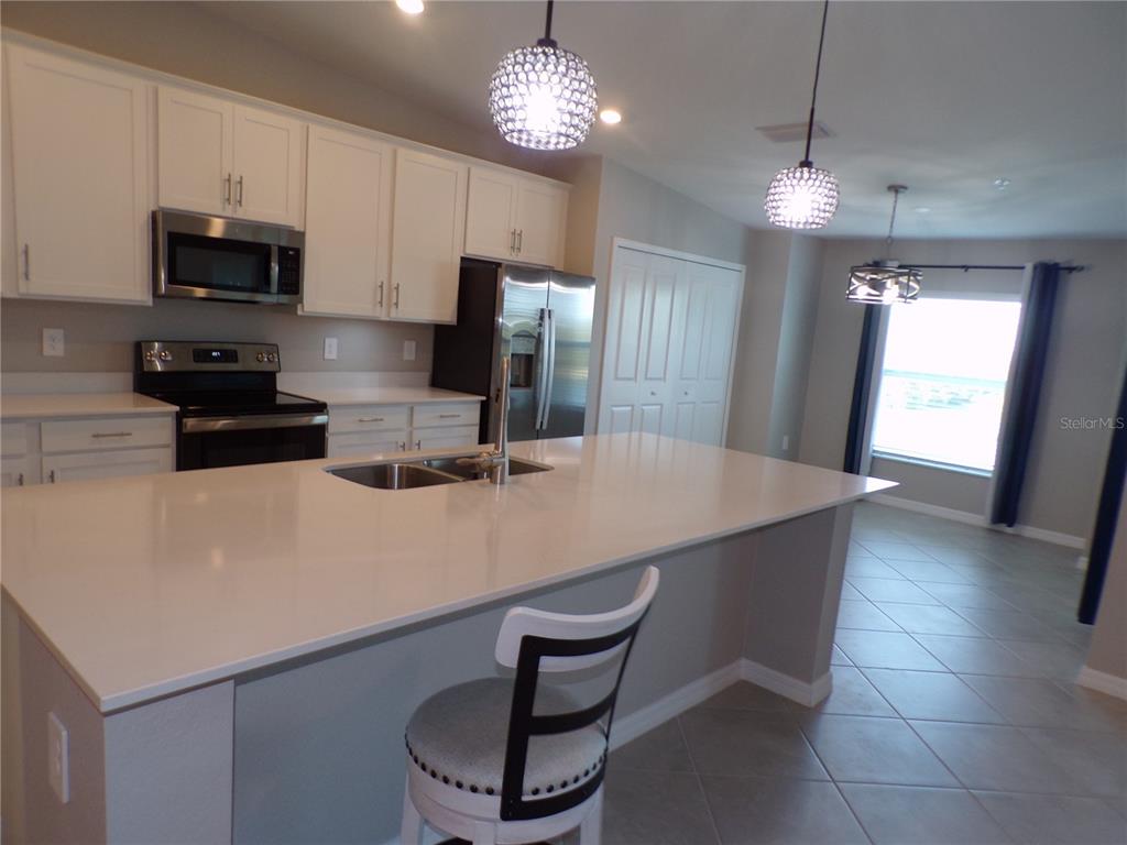 14271 Heritage Landing Boulevard, Unit 1526 Punta Gorda, FL 33955 - Photo 21 of 41 a kitchen with stainless steel appliances a table chairs in it and wooden floors