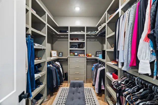 a view of walk in closet with clothes and shoes