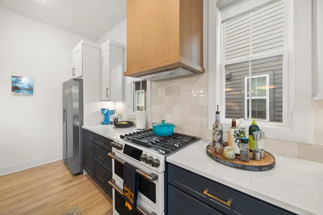 a kitchen with stainless steel appliances stove refrigerator and window