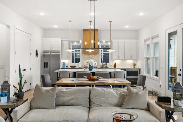 a living room with furniture kitchen view and stainless steel appliances