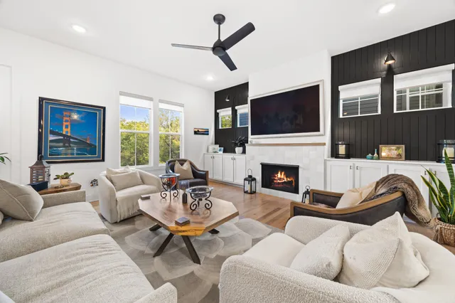 a living room with furniture a flat screen tv and a fireplace