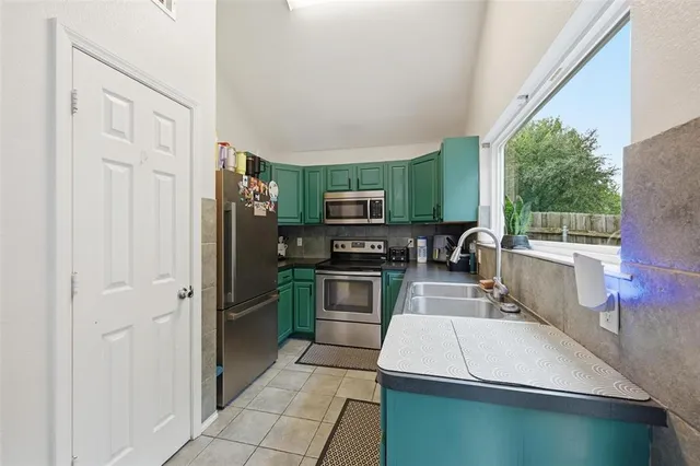 a kitchen with stainless steel appliances a stove microwave and sink