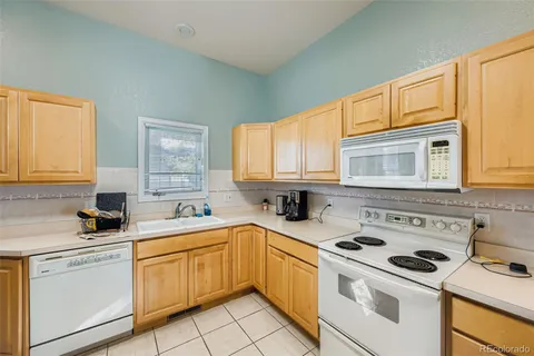a kitchen with white cabinets sink and white appliances