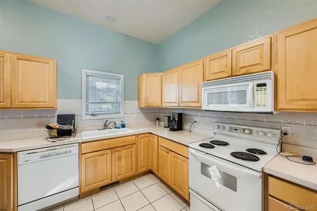 a kitchen with white cabinets sink and white appliances