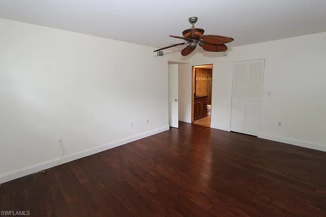 a view of a room with wooden floor and ceiling fan