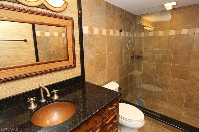a bathroom with a sink a toilet and shower