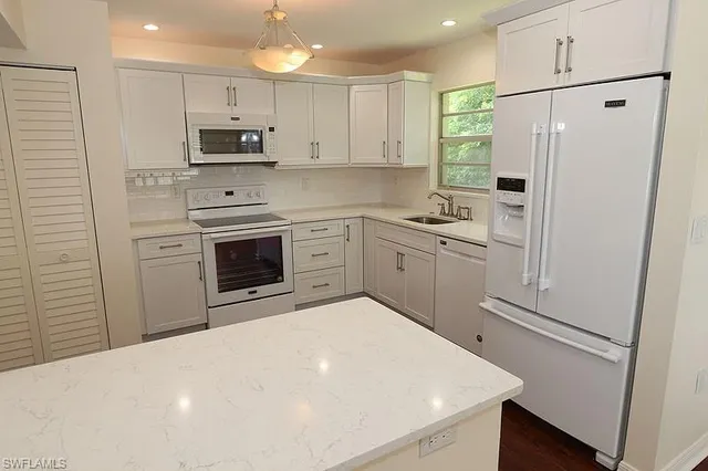a kitchen with white cabinets and stainless steel appliances