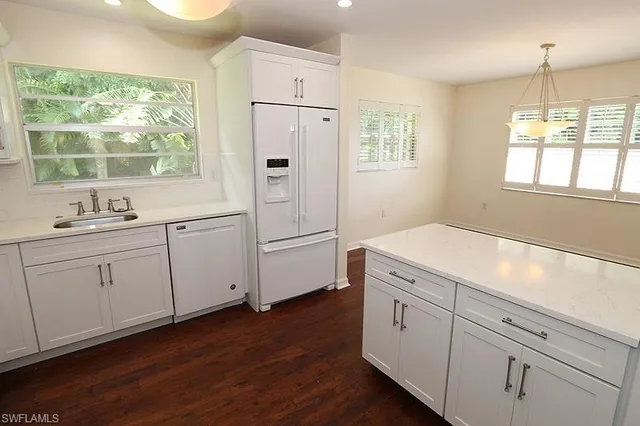 a kitchen with white cabinets and window