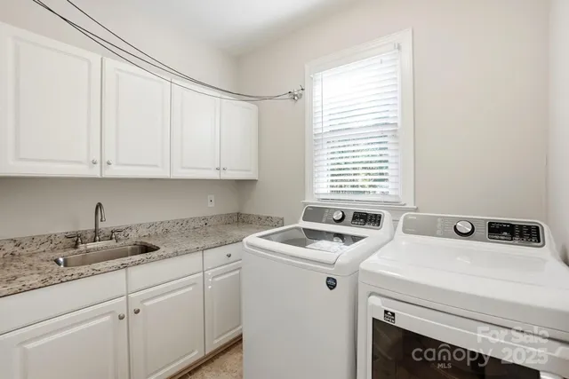a kitchen that has a sink cabinets counter space and a window