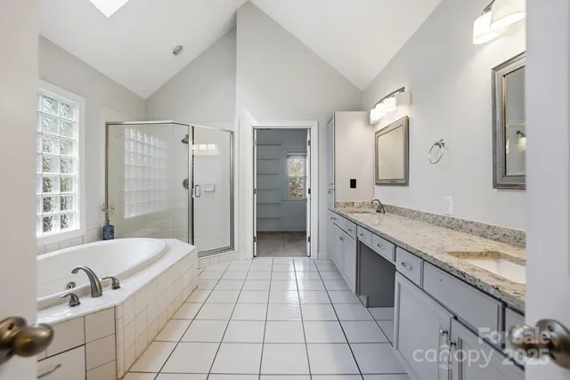 a spacious bathroom with a granite countertop tub sink and mirror