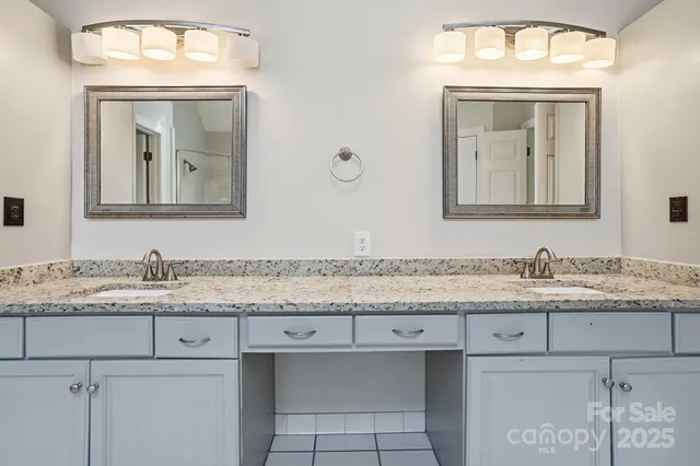 a bathroom with a granite countertop sink vanity and mirror