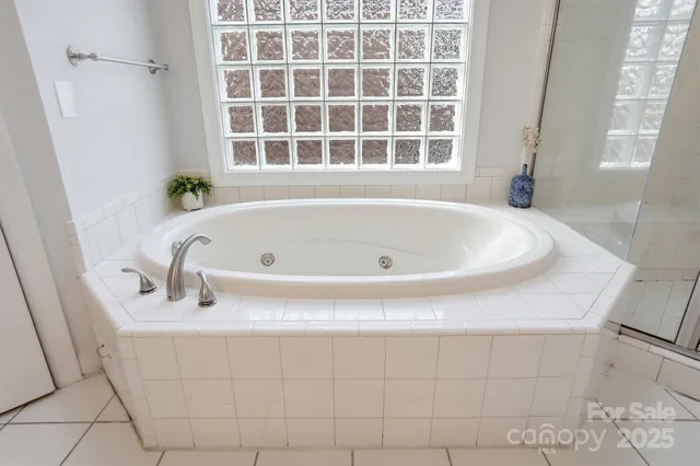 a white bath tub sitting in a bathroom next to a window