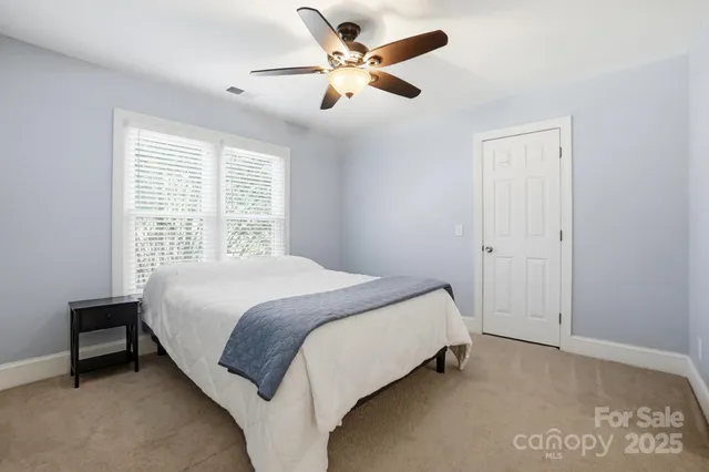 a bedroom with a bed and a ceiling fan