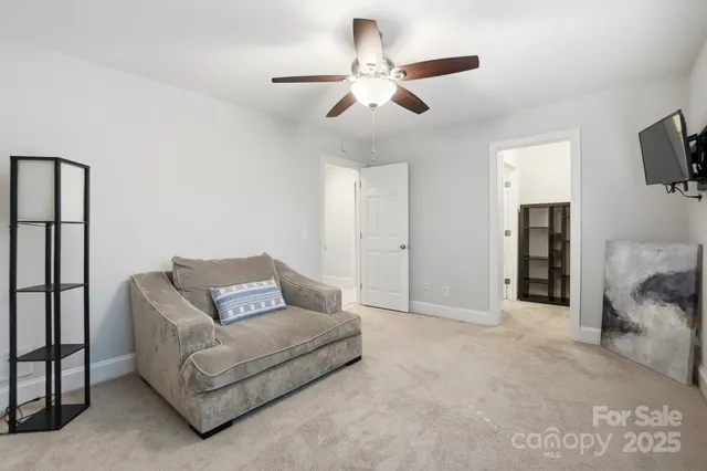 a living room with furniture and a ceiling fan