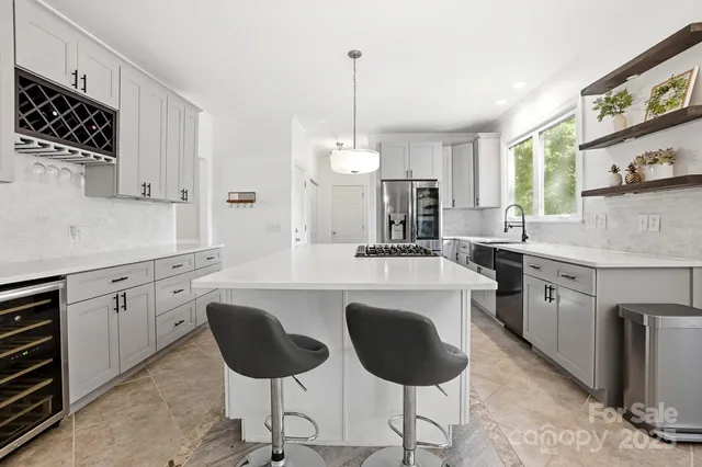 a kitchen with stainless steel appliances granite countertop a stove a sink dishwasher a refrigerator white cabinets with wooden floor