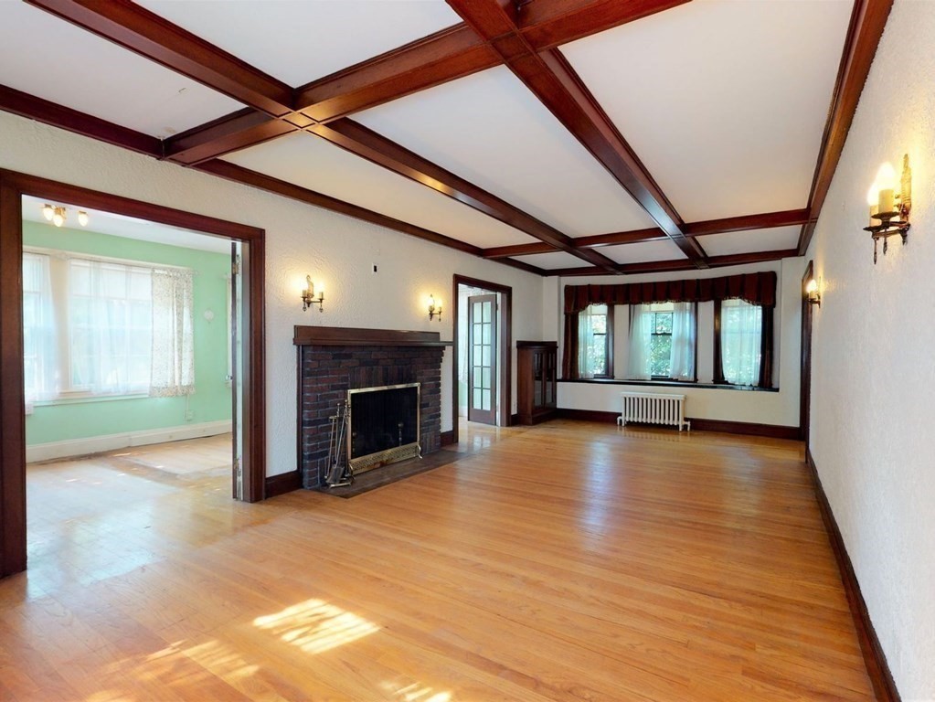 22 Hancock Road Brookline, MA 02445 - Photo 4 of 38 a view of an empty room with wooden floor fireplace and a window