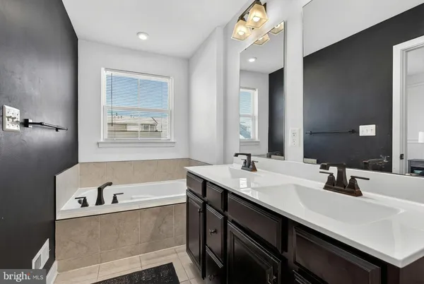 a bathroom with a tub sink and mirror