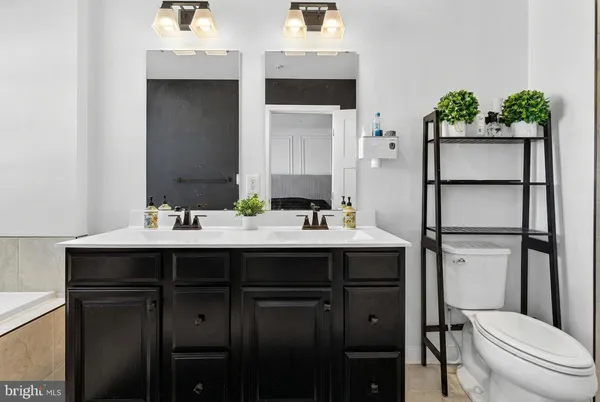 a bathroom with a sink vanity granite toilet and a mirror