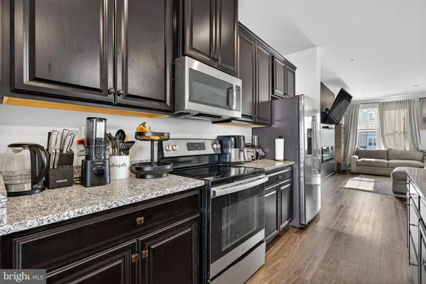 a kitchen with granite countertop stainless steel appliances and wooden cabinets