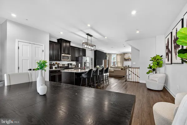 a kitchen with stainless steel appliances granite countertop wooden floors living room