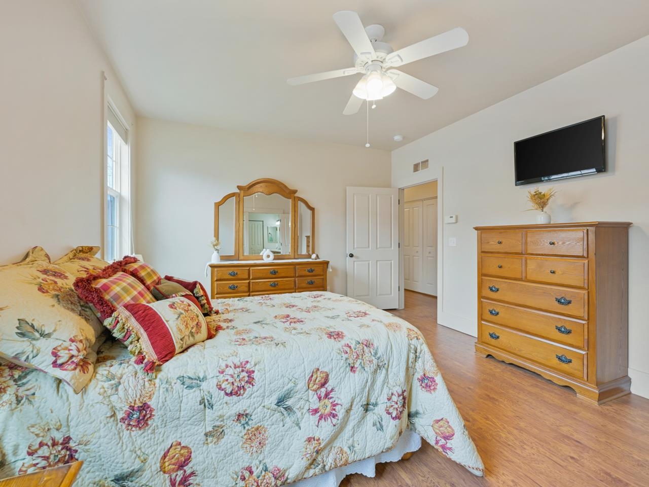 1110 Buttercup Lane Fruita, CO 81521 - Photo 18 of 27 a bedroom with a bed a dresser and a flat screen tv