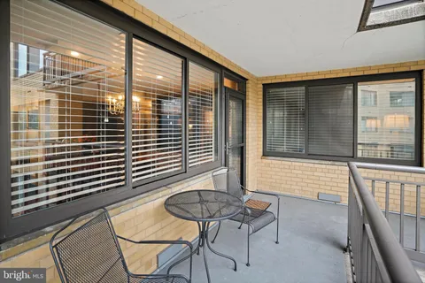 a balcony with table and chairs