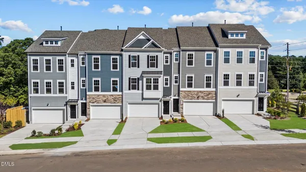 a view of multiple houses with yard and road