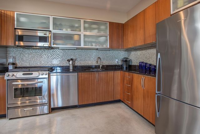 a kitchen with stainless steel appliances granite countertop a refrigerator and a sink