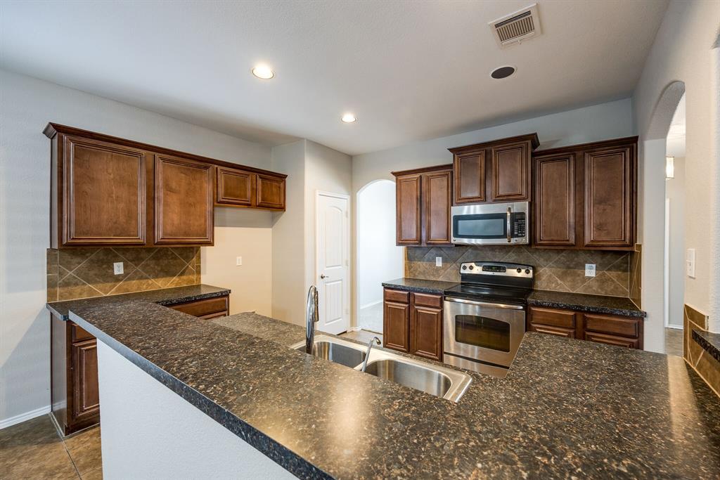 2228 Canyon Point McKinney, TX 75071 - Photo 12 of 40 a kitchen with stainless steel appliances granite countertop a stove a sink and a microwave