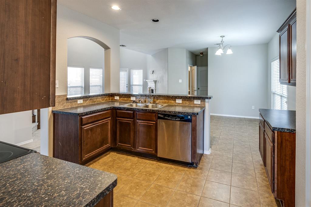2228 Canyon Point McKinney, TX 75071 - Photo 10 of 40 a kitchen with stainless steel appliances granite countertop a stove a sink and a refrigerator