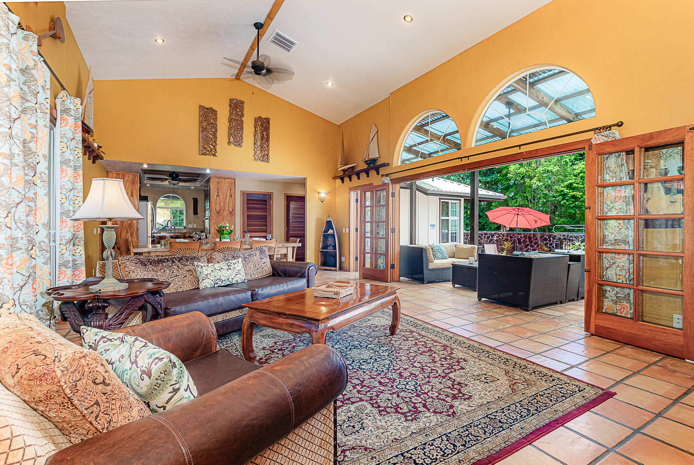 15-869 Lemiwai Road Keaau, HI 96749 - Photo 4 of 30 a living room with furniture a flat screen tv and a floor to ceiling window