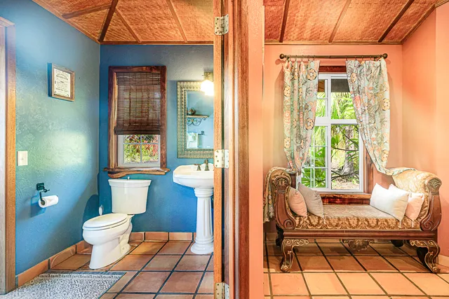 a bedroom with a bed a dresser next to a window