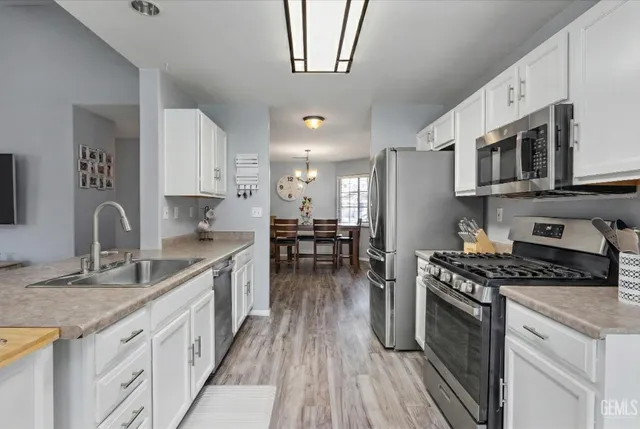 a kitchen with stainless steel appliances granite countertop a stove a sink and a refrigerator