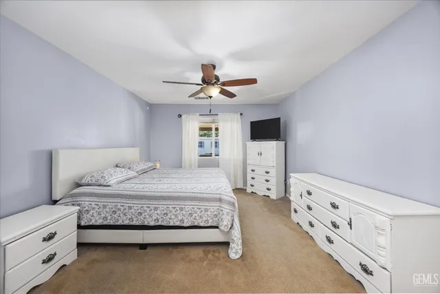 a bedroom with a large bed and a tv on the dresser