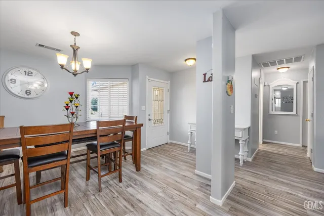a view of a dining room with furniture a chandelier and wooden floor